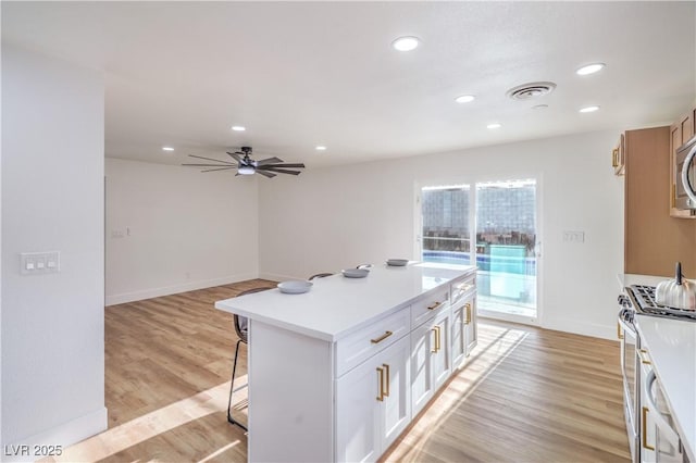 5239 Elgin Cir, Las Vegas, NV 89122 - kitchen with stainless steel appliances, a kitchen bar, recessed lighting, light countertops, and ceiling fan