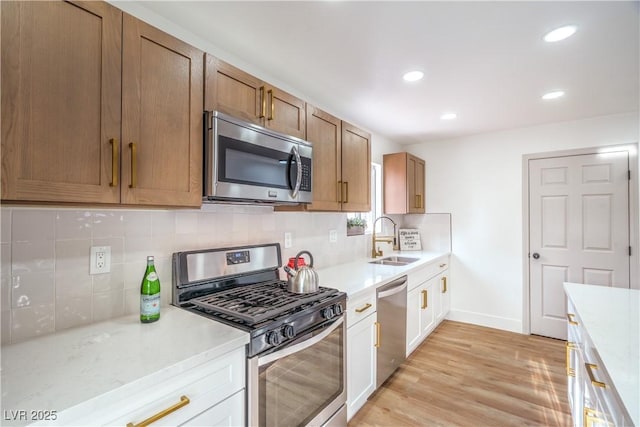 5239 Elgin Cir, Las Vegas, NV 89122 - kitchen with stainless steel appliances, a sink, light wood-style floors, tasteful backsplash, and recessed lighting