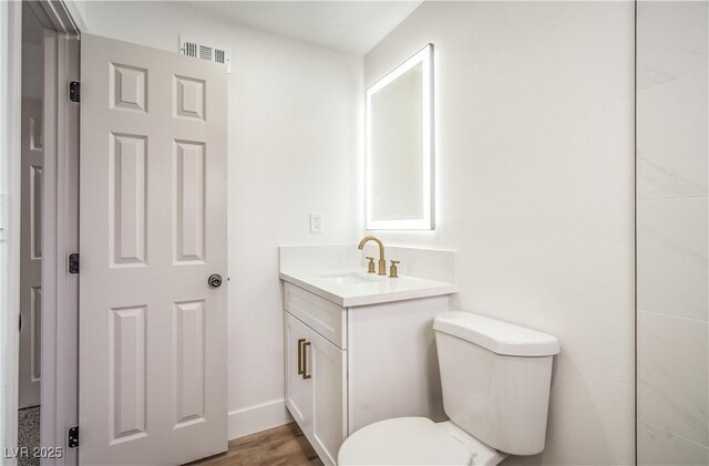 5239 Elgin Cir, Las Vegas, NV 89122 - bathroom with toilet, vanity, wood finished floors, and baseboards