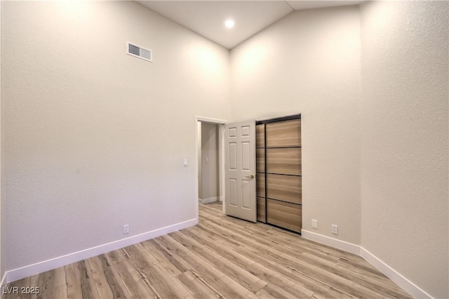 5010 Crooked Stick Way, Las Vegas, NV 89113 - unfurnished room with baseboards, light wood-style floors, and high vaulted ceiling