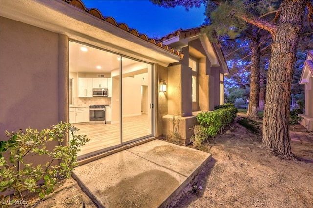 5010 Crooked Stick Way, Las Vegas, NV 89113 - exterior entry at night featuring a tiled roof and stucco siding