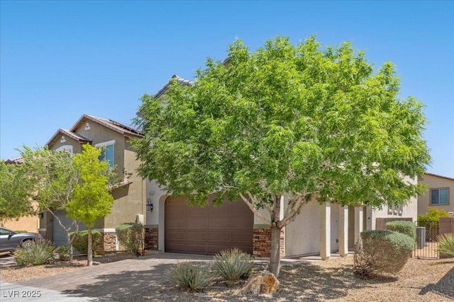 2276 Sky Island Dr, Henderson, NV 89002 - view of property hidden behind natural elements featuring concrete driveway, stucco siding, stone siding, and solar panels