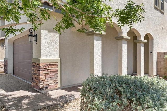 2276 Sky Island Dr, Henderson, NV 89002 - view of side of home featuring stone siding, stucco siding, and a garage