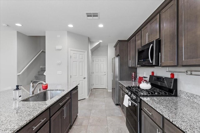 2276 Sky Island Dr, Henderson, NV 89002 - kitchen featuring stainless steel appliances, dark brown cabinets, light stone countertops, recessed lighting, and light tile patterned flooring