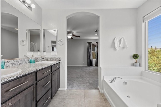 2276 Sky Island Dr, Henderson, NV 89002 - bathroom featuring double vanity, ceiling fan, a bath, and tile patterned flooring