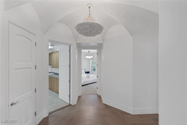 8130 Cassian Ct, Las Vegas, NV 89129 - hallway with baseboards, arched walkways, and a chandelier