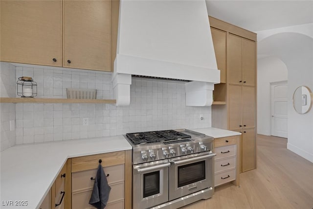 8130 Cassian Ct, Las Vegas, NV 89129 - kitchen featuring double oven range, open shelves, custom exhaust hood, arched walkways, and light countertops