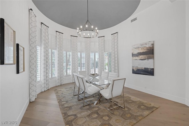 8130 Cassian Ct, Las Vegas, NV 89129 - dining space with a chandelier, wood finished floors, baseboards, and a towering ceiling