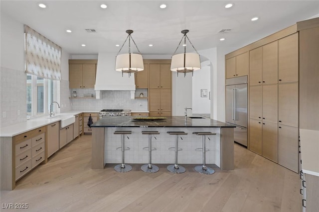 8130 Cassian Ct, Las Vegas, NV 89129 - kitchen featuring built in fridge, a sink, stove, a breakfast bar area, and light wood finished floors