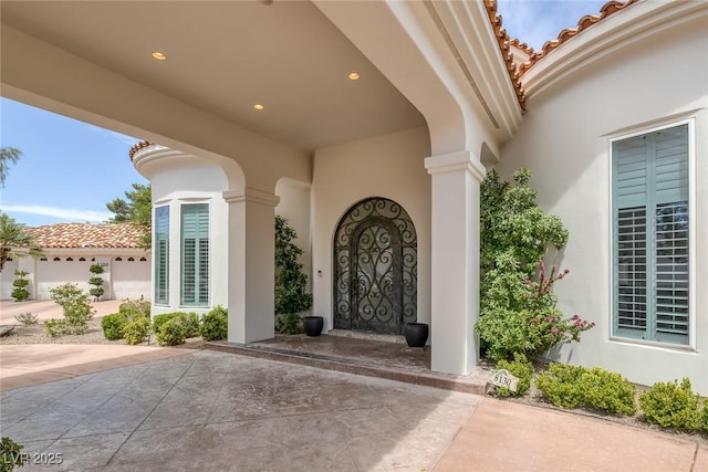 8130 Cassian Ct, Las Vegas, NV 89129 - doorway to property with stucco siding, a tile roof, and a patio area