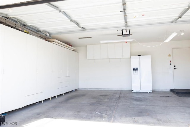 5400 Tassara Way Unit 106, Las Vegas, NV 89108 - garage featuring white fridge with ice dispenser and a garage door opener
