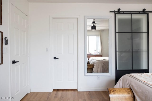 5400 Tassara Way Unit 106, Las Vegas, NV 89108 - bedroom featuring wood finished floors, baseboards, and a barn door