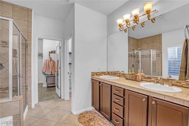 153 Via Di Mello, Henderson, NV 89011 - full bathroom featuring a stall shower, double vanity, tile patterned flooring, and a walk in closet