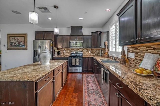 153 Via Di Mello, Henderson, NV 89011 - kitchen featuring appliances with stainless steel finishes, a sink, a center island, dark wood-style floors, and light stone counters