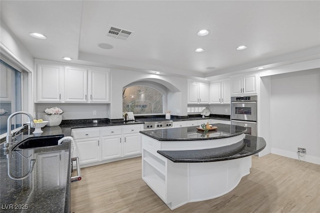 11158 Antonine Wall Ct, Las Vegas, NV 89141 - kitchen with stainless steel double oven, a sink, recessed lighting, white cabinetry, and a center island