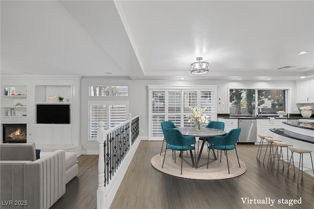 11158 Antonine Wall Ct, Las Vegas, NV 89141 - dining space featuring wood finished floors, recessed lighting, a glass covered fireplace, baseboards, and built in shelves