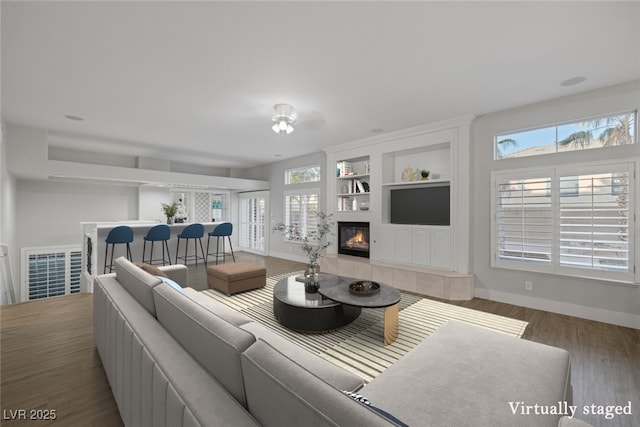11158 Antonine Wall Ct, Las Vegas, NV 89141 - living area with a fireplace, baseboards, wood finished floors, built in features, and ceiling fan