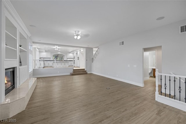 11158 Antonine Wall Ct, Las Vegas, NV 89141 - unfurnished living room featuring a premium fireplace, wood finished floors, baseboards, and stairs