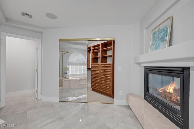 11158 Antonine Wall Ct, Las Vegas, NV 89141 - unfurnished living room featuring a glass covered fireplace, baseboards, and marble finish flooring