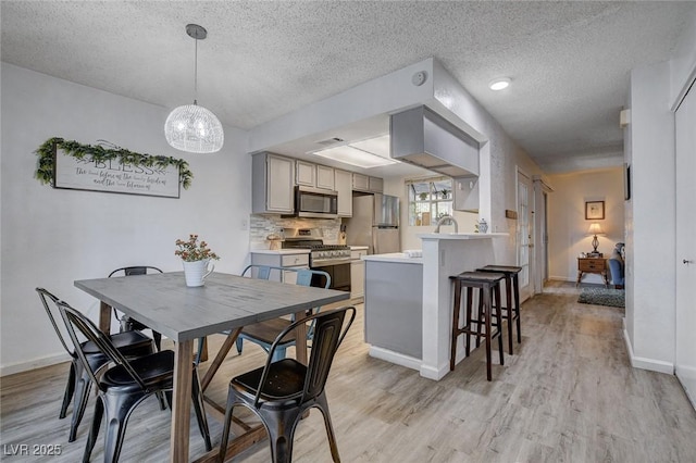 227 N Lamb Blvd Unit B, Las Vegas, NV 89110 - dining space with a textured ceiling, light wood-type flooring, baseboards, and a chandelier