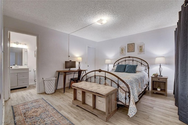 227 N Lamb Blvd Unit B, Las Vegas, NV 89110 - bedroom featuring light wood-style floors, a textured ceiling, a sink, ensuite bathroom, and baseboards