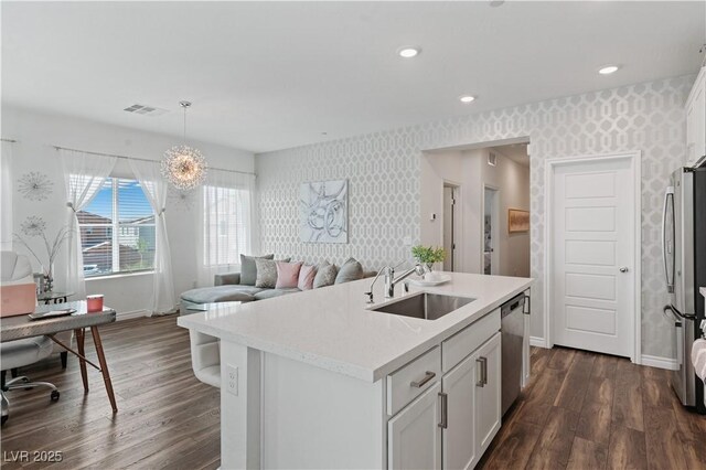 3729 Canis Minor Ln Unit 10206, Henderson, NV 89052 - kitchen featuring wallpapered walls, a sink, stainless steel appliances, baseboards, and dark wood-type flooring