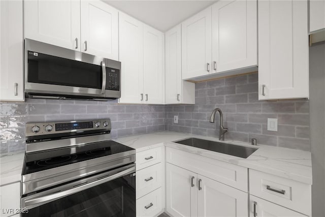 5817 Glen Eagles Ln, Las Vegas, NV 89108 - kitchen with appliances with stainless steel finishes, a sink, white cabinetry, and tasteful backsplash