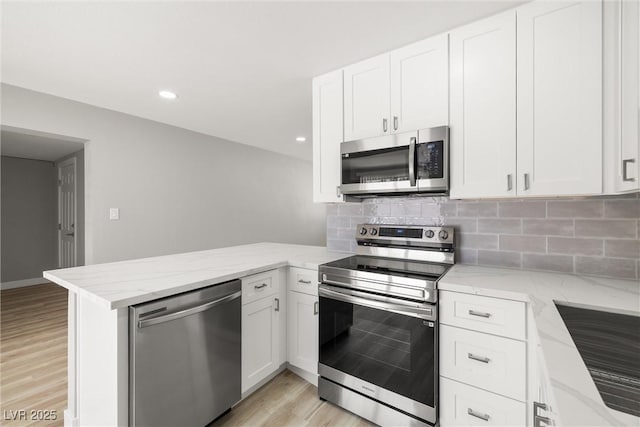 5817 Glen Eagles Ln, Las Vegas, NV 89108 - kitchen with appliances with stainless steel finishes, a peninsula, white cabinets, light wood-style flooring, and recessed lighting