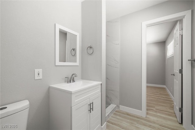 5817 Glen Eagles Ln, Las Vegas, NV 89108 - bathroom with toilet, vanity, wood finished floors, a stall shower, and baseboards