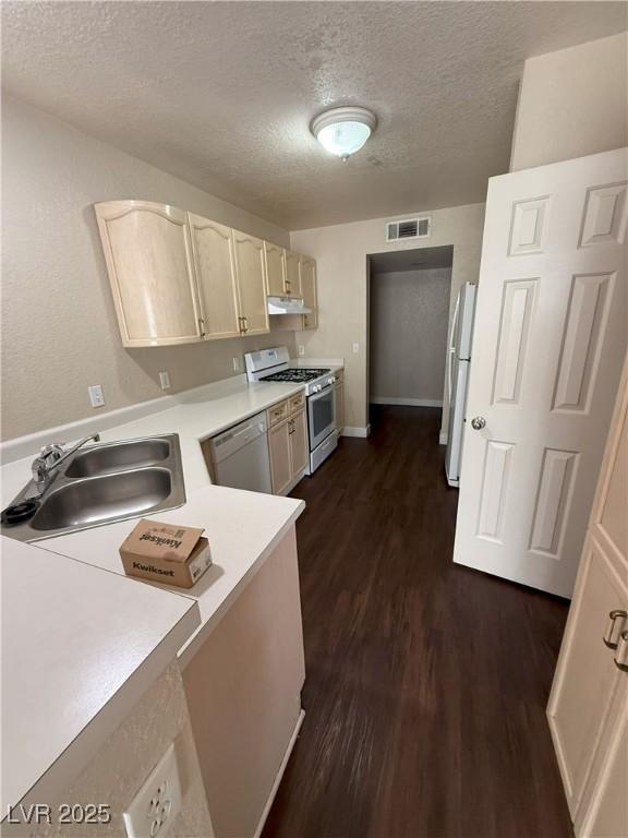 7969 Cina Ave, Las Vegas, NV 89147 - kitchen with gas stove, stainless steel dishwasher, freestanding refrigerator, a textured ceiling, and light countertops