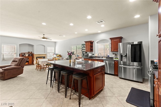 7641 Lani Dawn St, Las Vegas, NV 89149 - kitchen featuring appliances with stainless steel finishes, open floor plan, a sink, a breakfast bar, and ceiling fan