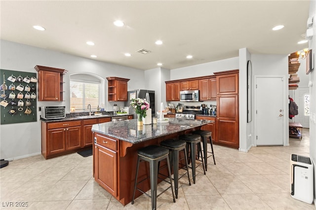 7641 Lani Dawn St, Las Vegas, NV 89149 - kitchen with stainless steel appliances, open shelves, a breakfast bar area, a kitchen island, and recessed lighting