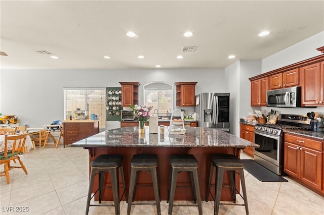 7641 Lani Dawn St, Las Vegas, NV 89149 - kitchen with appliances with stainless steel finishes, open shelves, a center island with sink, a kitchen breakfast bar, and recessed lighting