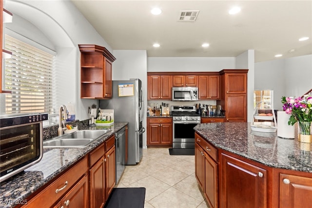 7641 Lani Dawn St, Las Vegas, NV 89149 - kitchen featuring stainless steel appliances, a sink, open shelves, light tile patterned floors, and dark stone countertops