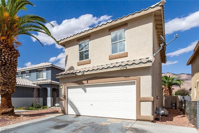 1360 Angel Falls St, Las Vegas, NV 89142 - mediterranean / spanish house featuring an attached garage, fence, driveway, stucco siding, and a tiled roof