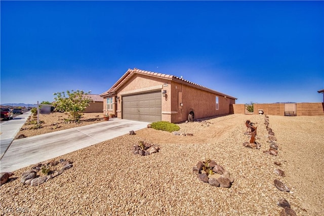 5460 Chippewa, Pahrump, NV 89061 - view of property exterior featuring driveway, stucco siding, a tiled roof, and a garage