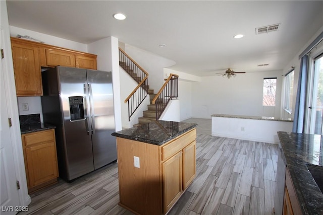 3440 Crystal Tower St, Las Vegas, NV 89129 - kitchen with stainless steel fridge with ice dispenser, light wood finished floors, ceiling fan, dark stone countertops, and a center island