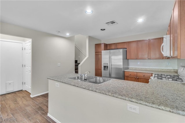 7632 Calico Fields St, Las Vegas, NV 89149 - kitchen featuring stainless steel fridge with ice dispenser, range, a sink, wood finished floors, and a peninsula