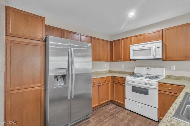 7632 Calico Fields St, Las Vegas, NV 89149 - kitchen with white appliances, dark wood-style floors, brown cabinets, recessed lighting, and a sink