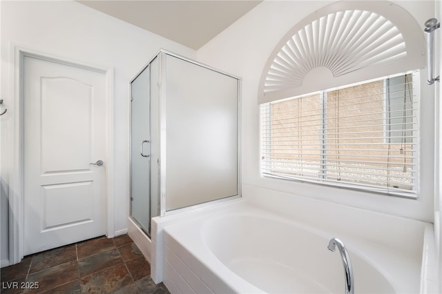 bathroom with a garden tub, a stall shower, and stone finish floors