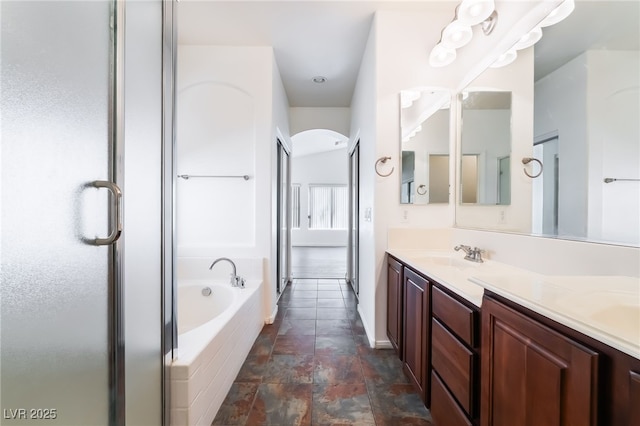 full bathroom with a bath, double vanity, and a shower stall
