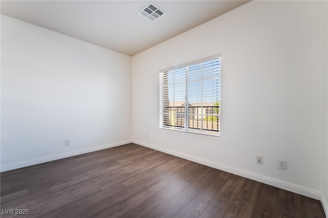 empty room featuring dark wood-type flooring and baseboards