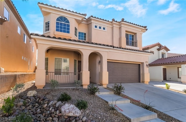 mediterranean / spanish-style house featuring a porch, stucco siding, and an attached garage
