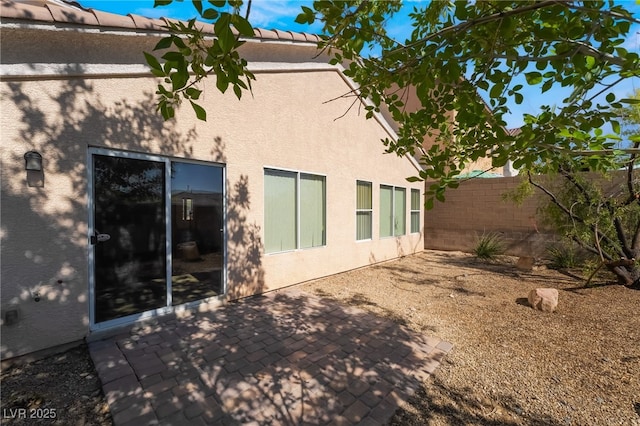 back of house featuring stucco siding and a patio area