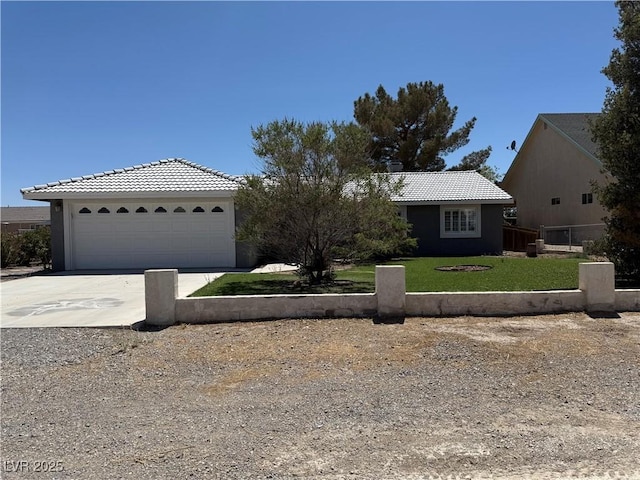 311 Glenoaks St, Pahrump, NV 89048 - view of front facade with a tile roof, a garage, a front yard, stucco siding, and concrete driveway