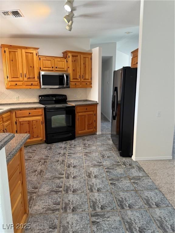 311 Glenoaks St, Pahrump, NV 89048 - kitchen with black appliances, decorative backsplash, brown cabinets, and baseboards