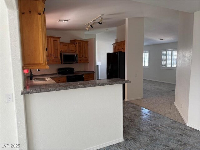 311 Glenoaks St, Pahrump, NV 89048 - kitchen with black appliances, a sink, dark countertops, a peninsula, and baseboards