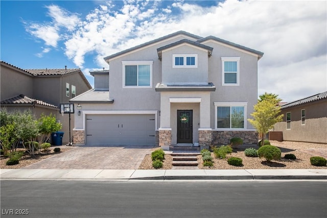5733 Coral Sun St, North Las Vegas, NV 89031 - view of front facade with stone siding, an attached garage, stucco siding, and decorative driveway