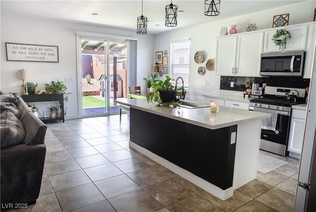 5733 Coral Sun St, North Las Vegas, NV 89031 - kitchen with stainless steel appliances, a sink, open floor plan, and white cabinets