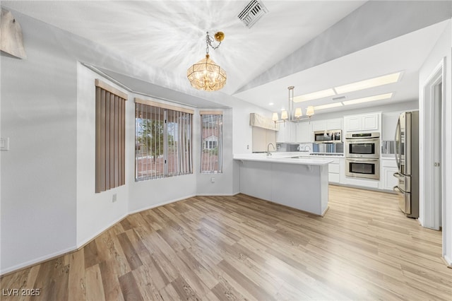 9917 Arbuckle Dr, Las Vegas, NV 89134 - kitchen featuring a chandelier, appliances with stainless steel finishes, a peninsula, light countertops, and light wood-type flooring